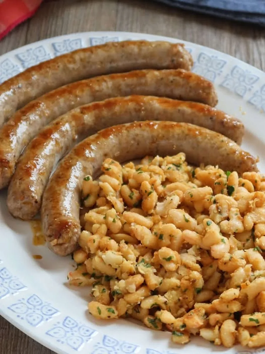 Botifarra amb seques en una plata, amb quatre botifarres de porc daurades i mongetes saltejades amb julivert