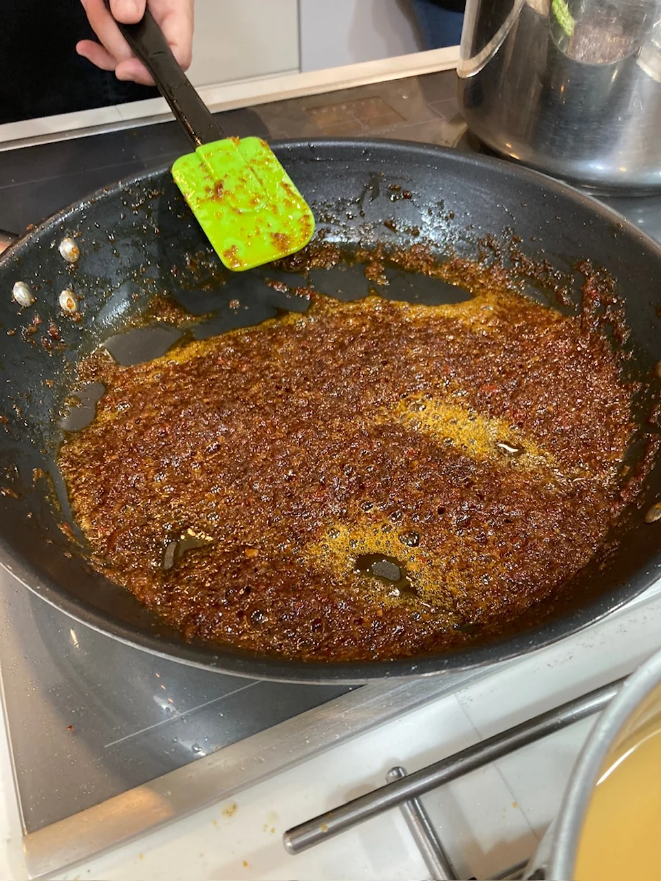 Sofregit de ceba i tomàquet en una cassola de ferro, a foc baix, amb textura daurada i concentrada